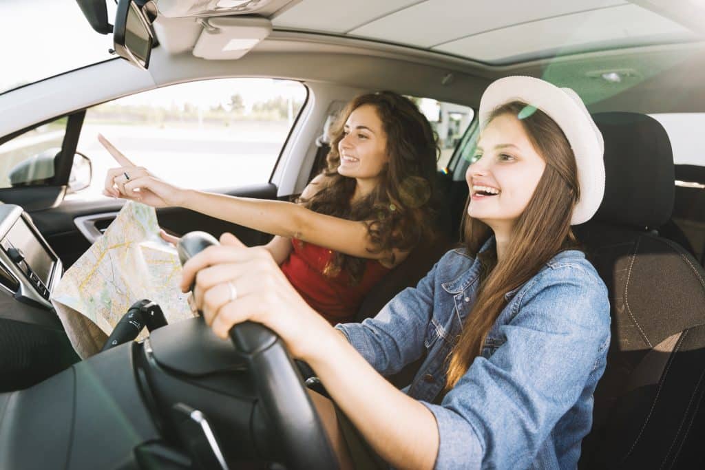 Dos Muchachas Manejando un Auto Rentado en sus Vacaciones